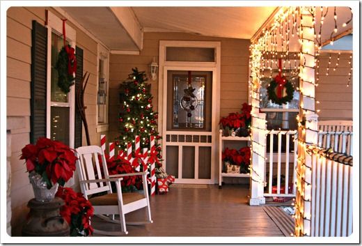 a porch decorated for christmas with rocking chairs and wreaths