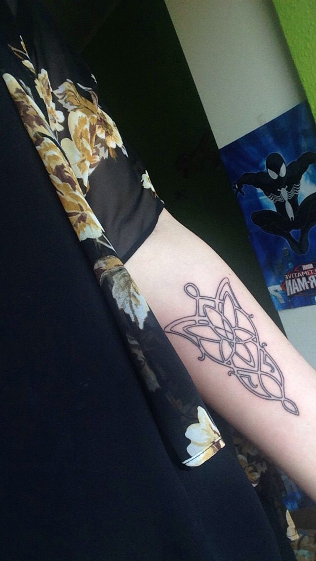 a person with a tattoo on their arm that has a spiderman symbol on it