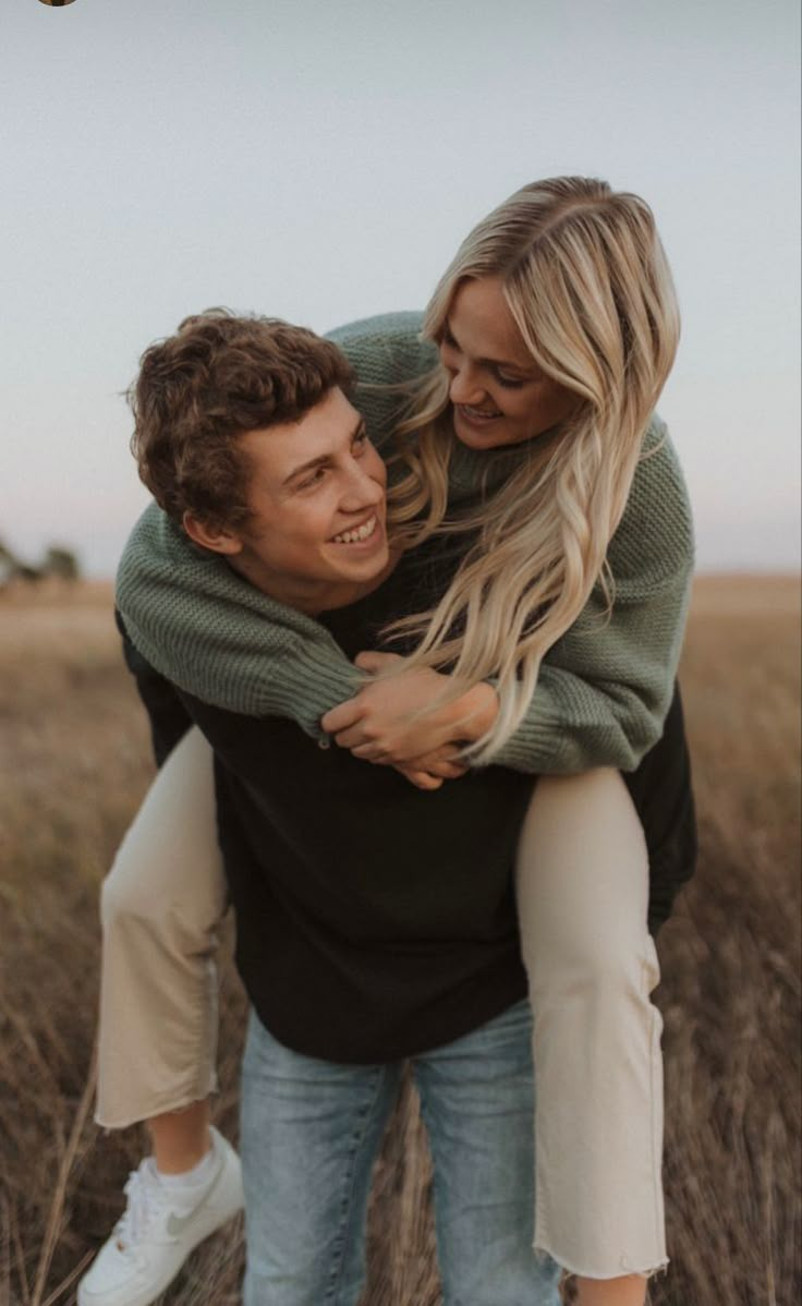 a man holding a woman in the middle of a field