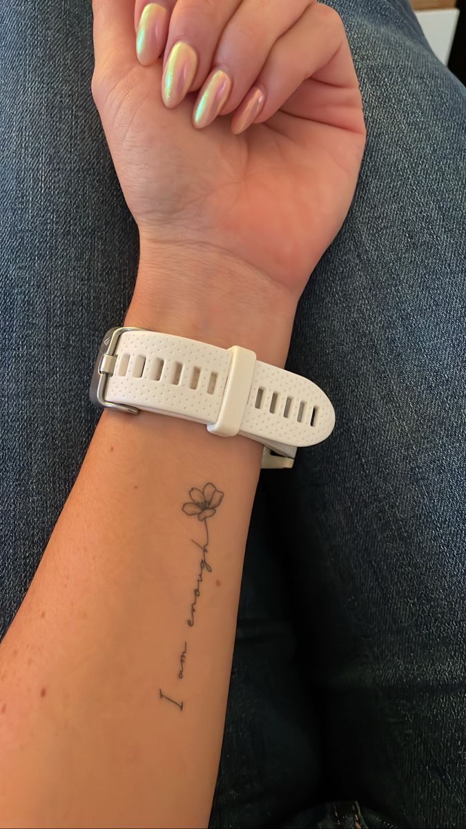 a woman's arm with a wristband on it and a flower tattooed on the wrist