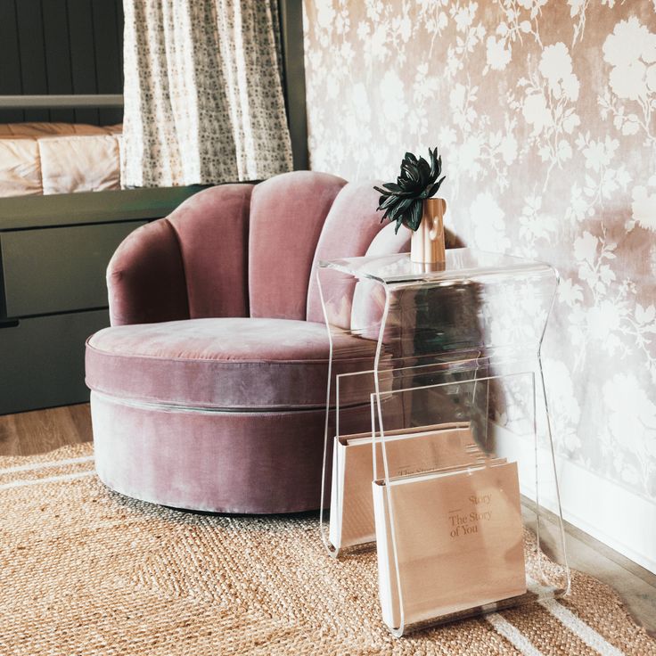 a pink chair sitting on top of a rug next to a bed