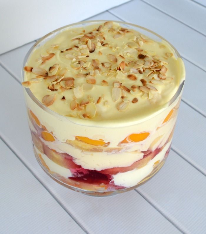 a layered dessert in a glass dish with nuts on top