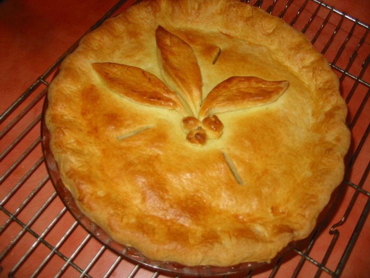 a baked pie sitting on top of a metal rack