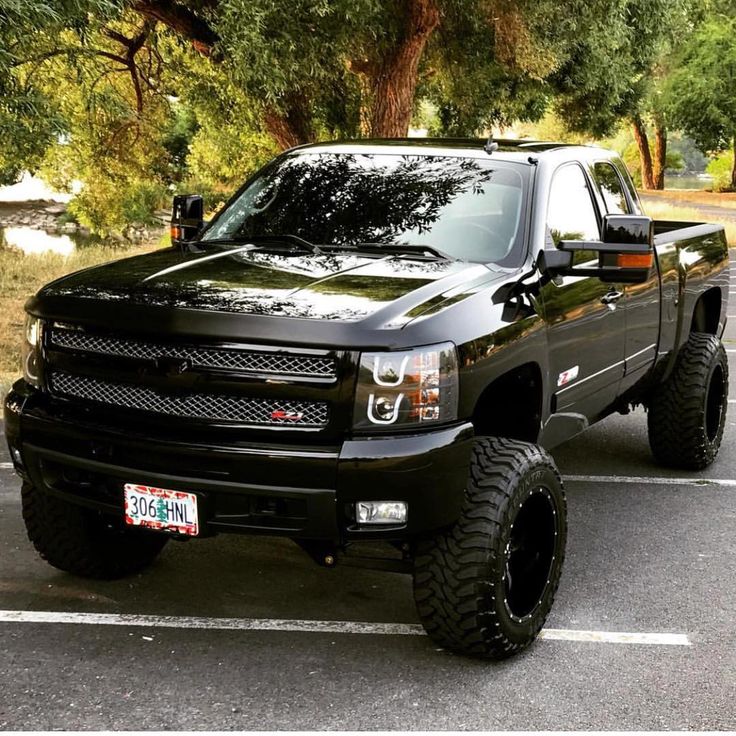 a large black truck parked in a parking lot