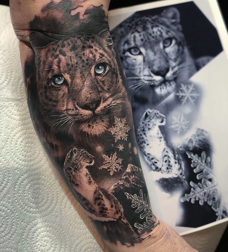 a man's arm with an animal and snowflakes tattoo on the forearm