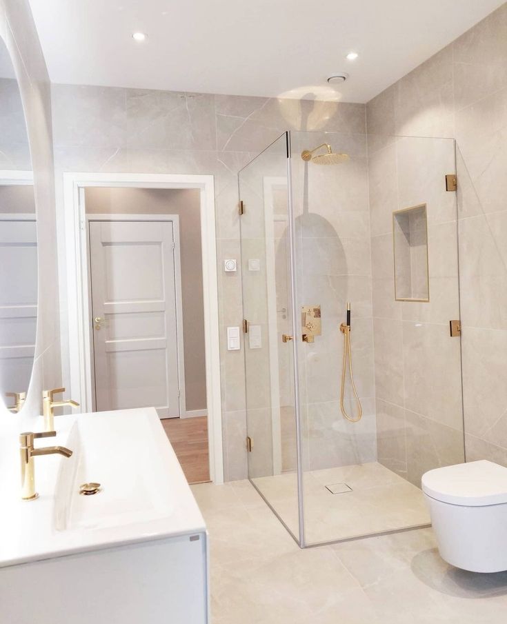 a bathroom with a walk in shower next to a white toilet and sink under a mirror