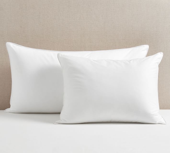 two white pillows sitting on top of a bed