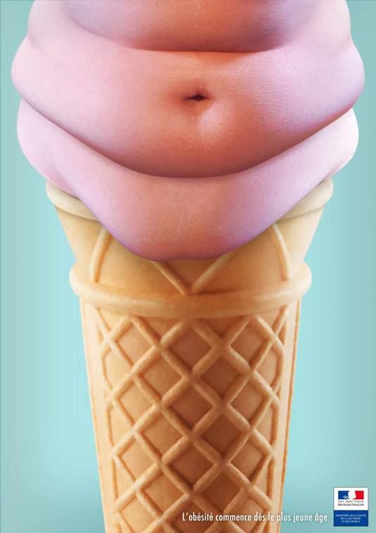 an ice cream cone with pink icing on it's top and the shape of a pregnant belly