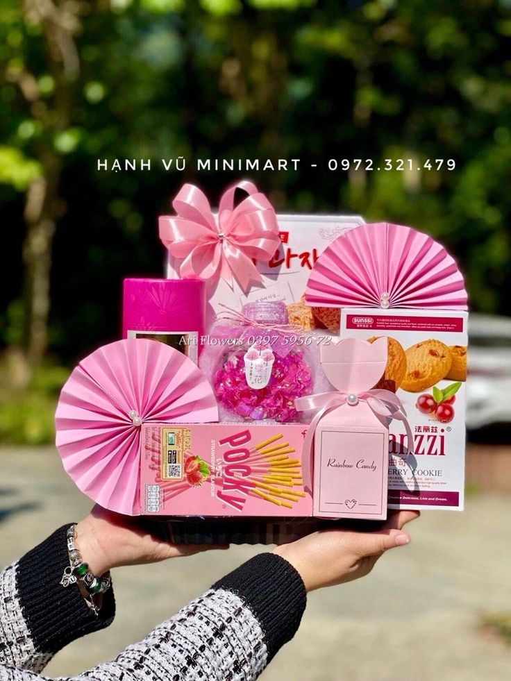 a person holding up a pink box with different items in it's palm hand