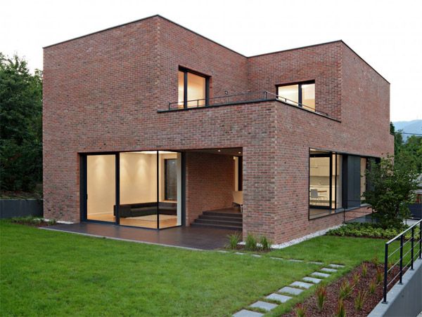 a brick house with large windows and stairs leading up to the upper floor area,