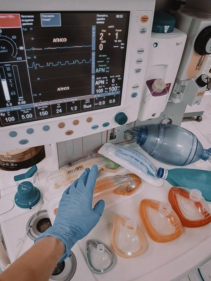 a person in blue gloves is looking at a computer screen with medical equipment on it