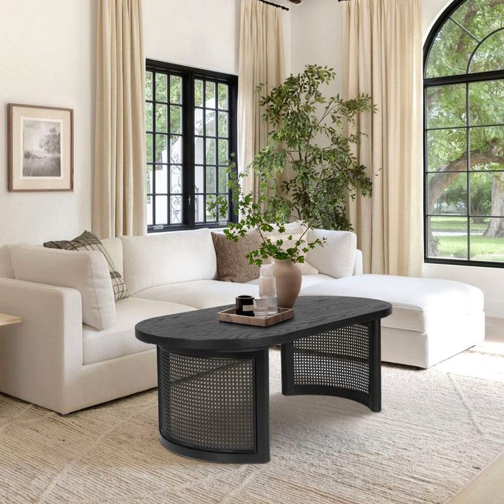 a living room with white furniture and large windows that look out onto the trees outside