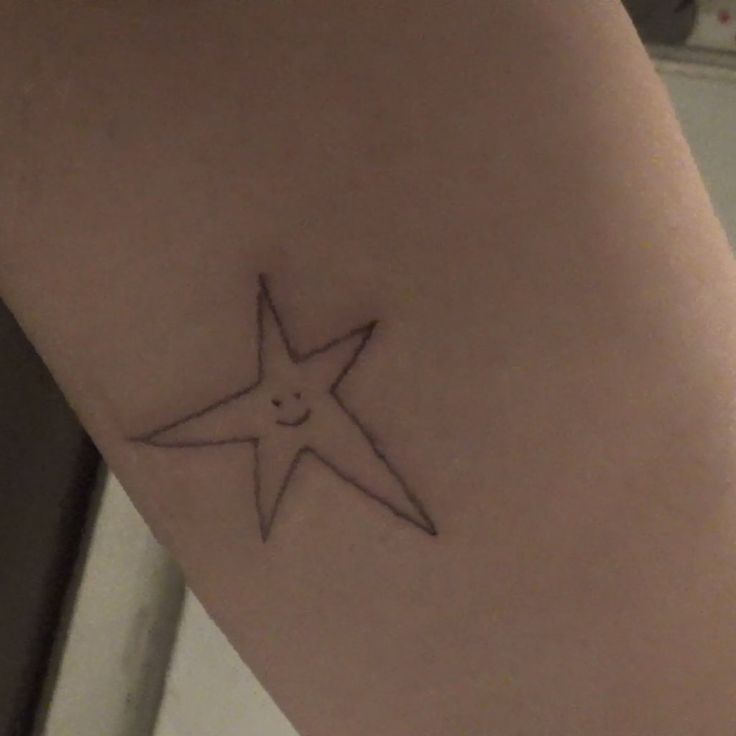 a small star tattoo on the leg