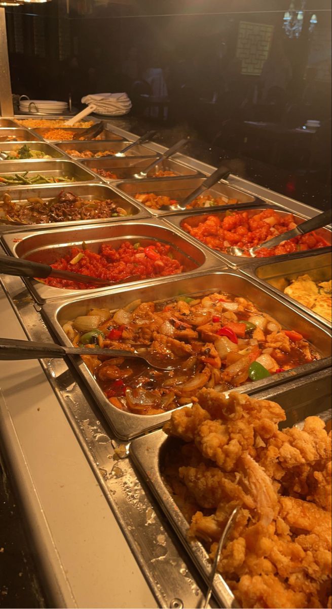 many trays of food are lined up on the buffet table, ready to be eaten