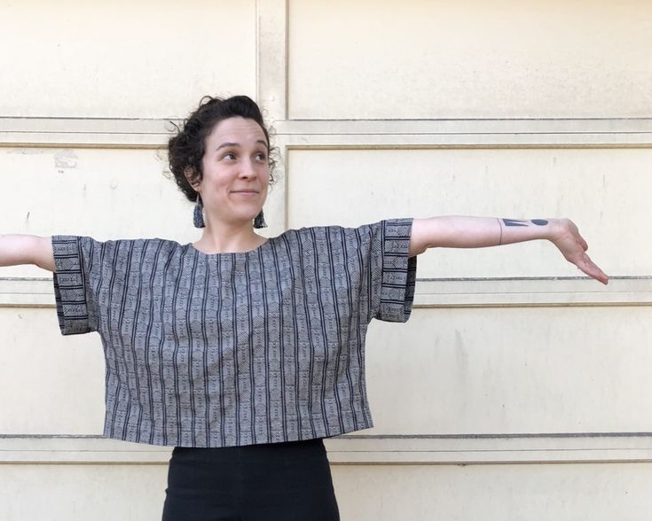 a woman standing in front of a garage door with her arms stretched out to the side