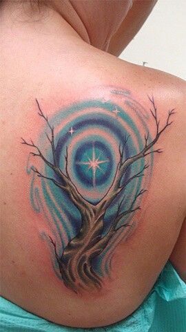 a woman with a tree tattoo on her shoulder