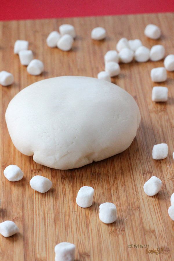 a wooden cutting board topped with white marshmallows