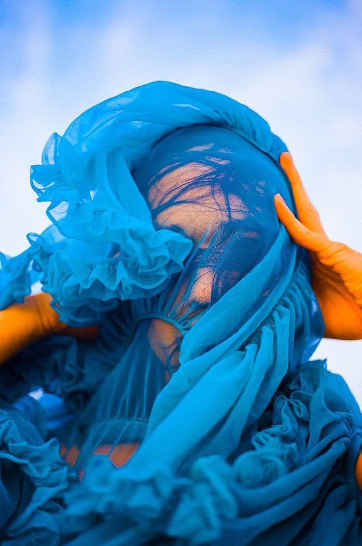 a woman with blue hair and orange gloves