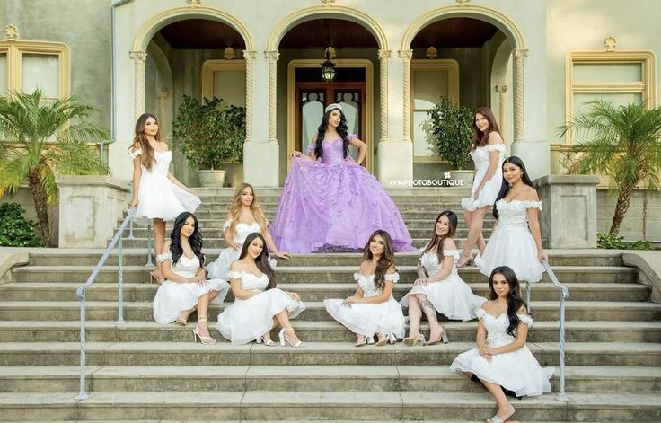 a group of beautiful women sitting on top of steps next to each other in white dresses