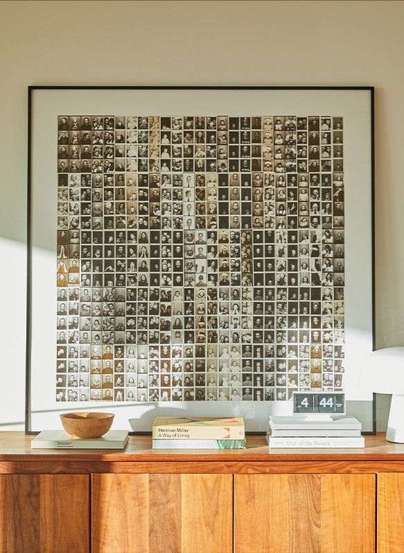 a wooden cabinet with a bowl on top of it next to a large framed artwork