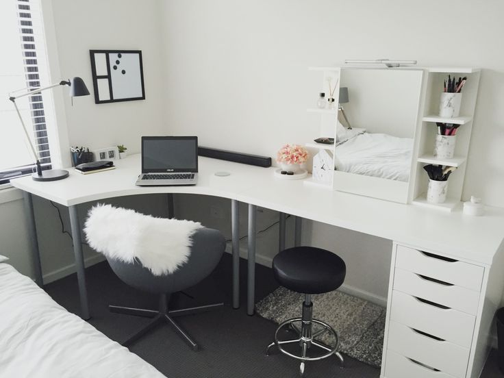 a white desk with a laptop on top of it next to a chair and bed