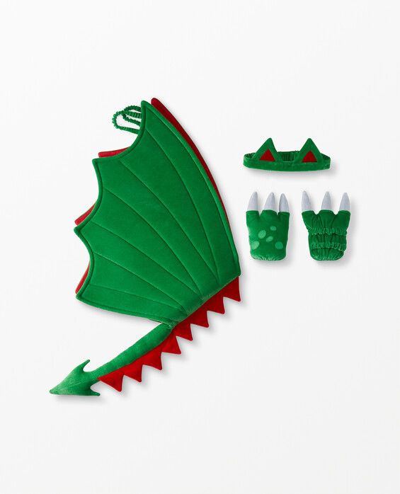 a green and red dragon costume next to other accessories on a white surface with one wing folded down