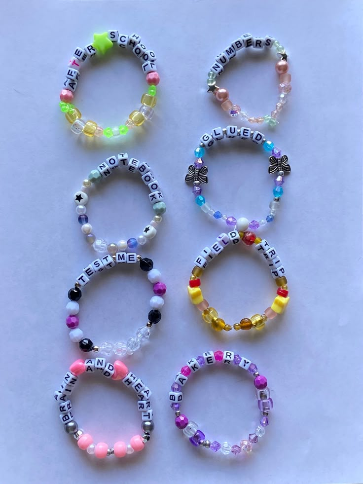 six bracelets with words and beads on them