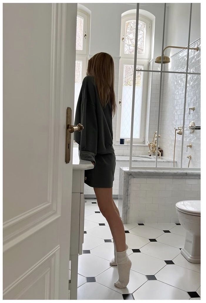 a woman is standing at the door of a bathroom