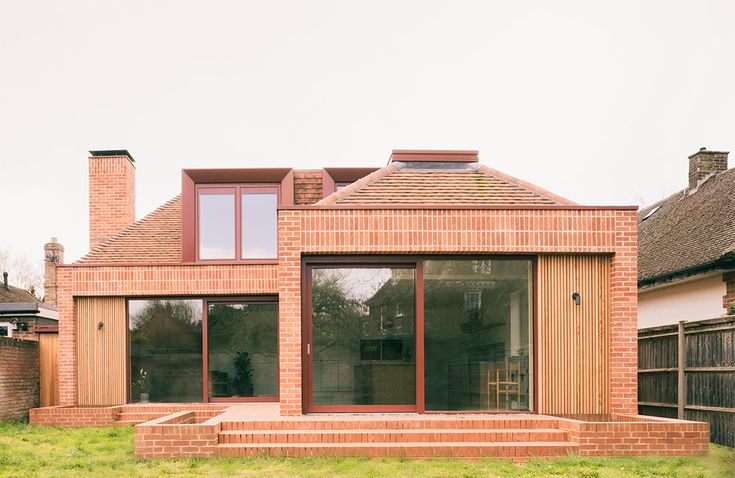 a brick house sitting on top of a lush green field