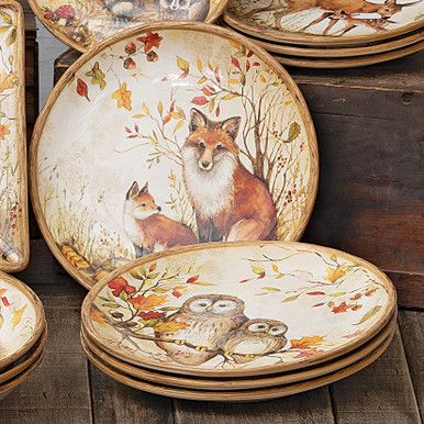 an assortment of decorative plates with animals painted on them, sitting on a wooden surface