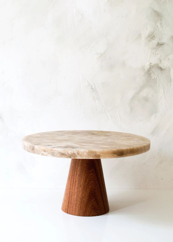 a round wooden table sitting on top of a white floor