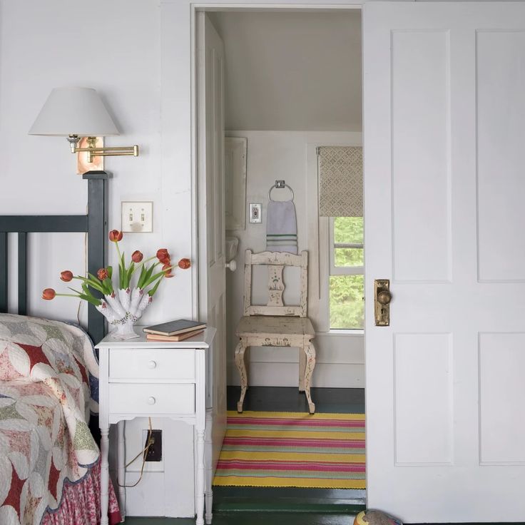 an open door leading to a bedroom with a bed and dresser in it, next to a rug on the floor