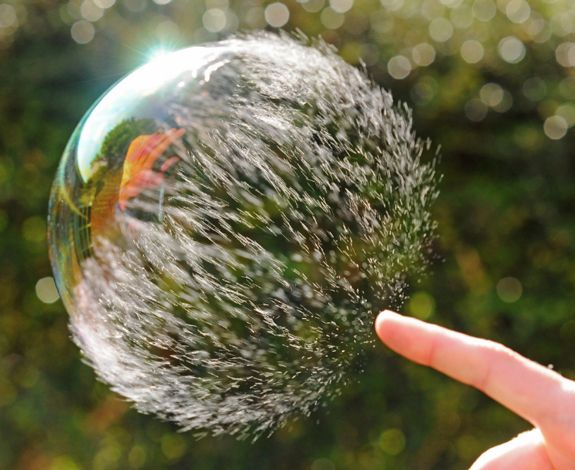 a hand is holding a soap bubble in the air