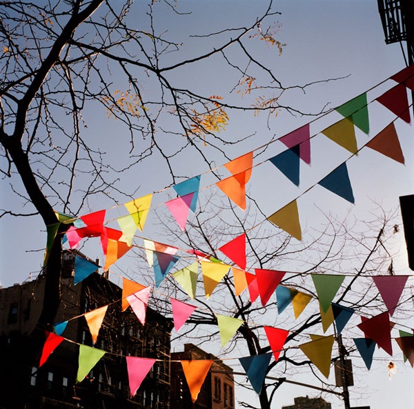 there are many colorful flags hanging in the street