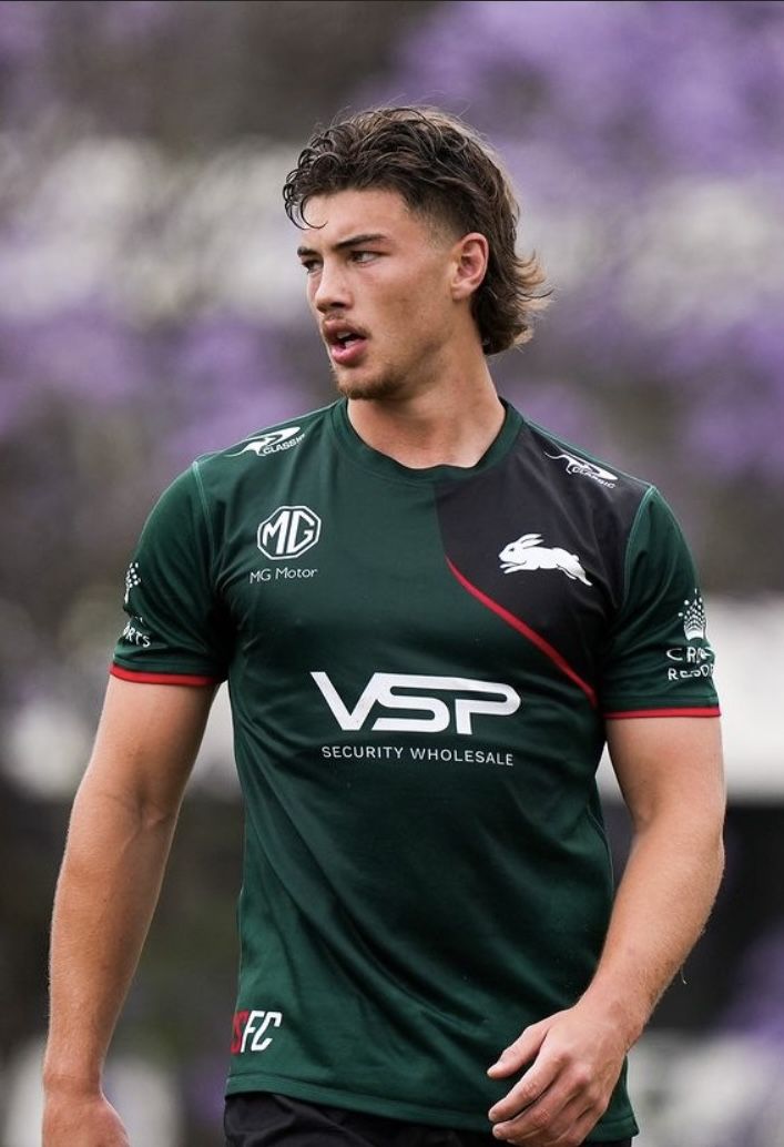 a young man wearing a green shirt and black shorts