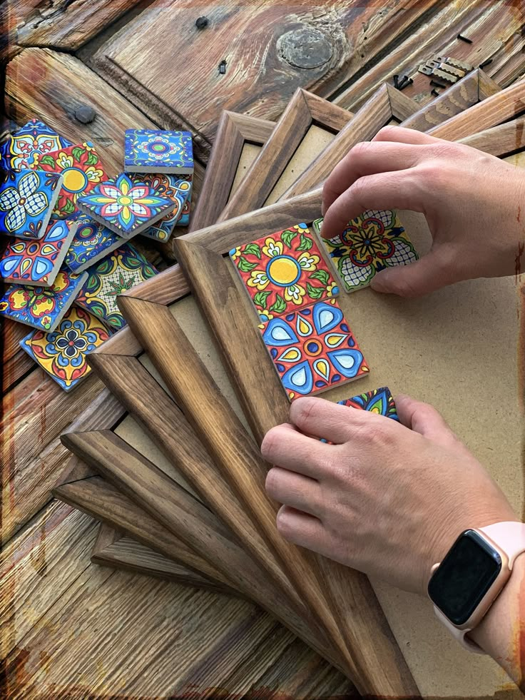 a person is working on some art work with wood and glass pieces in front of them