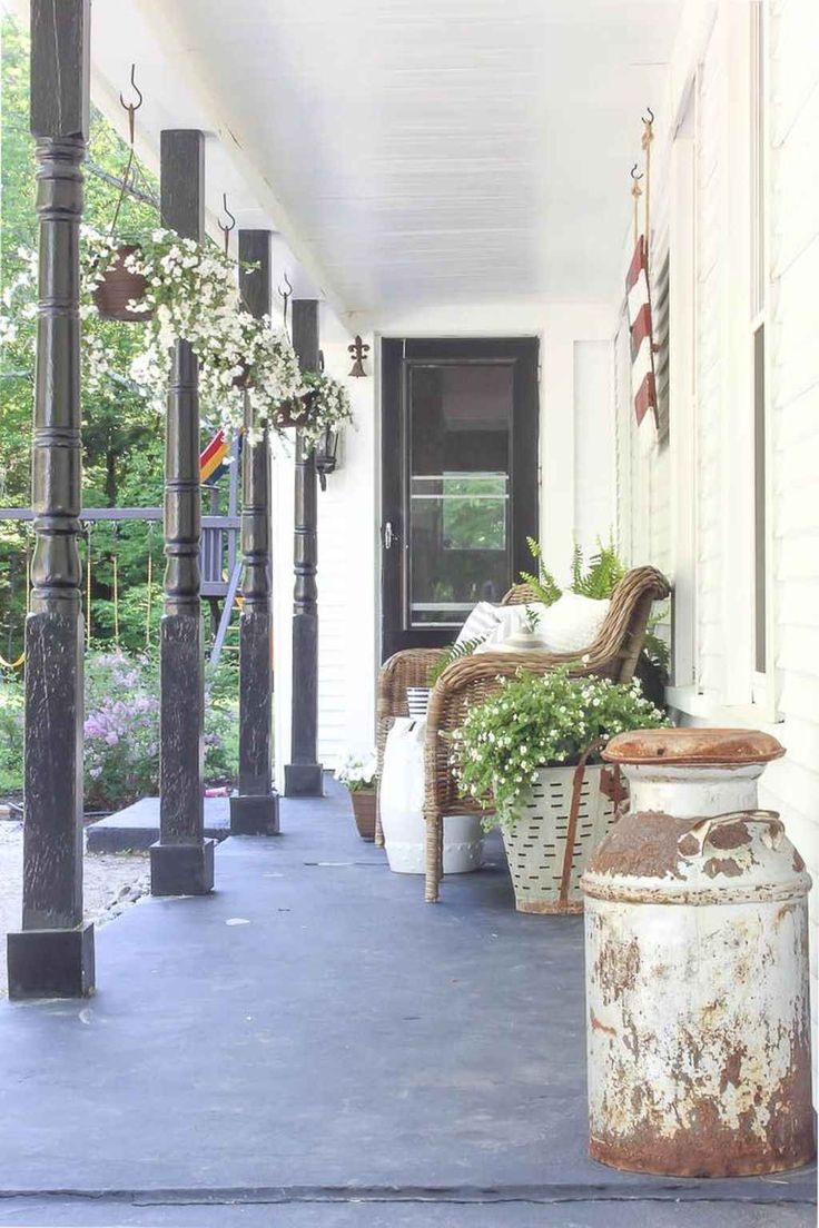 the porch is decorated with an american flag and some potted plants on it's side