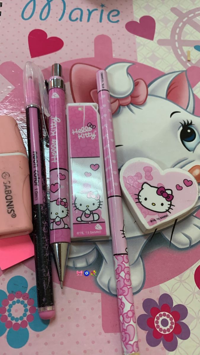 the hello kitty stationery is on display with pens and pencils in front of it