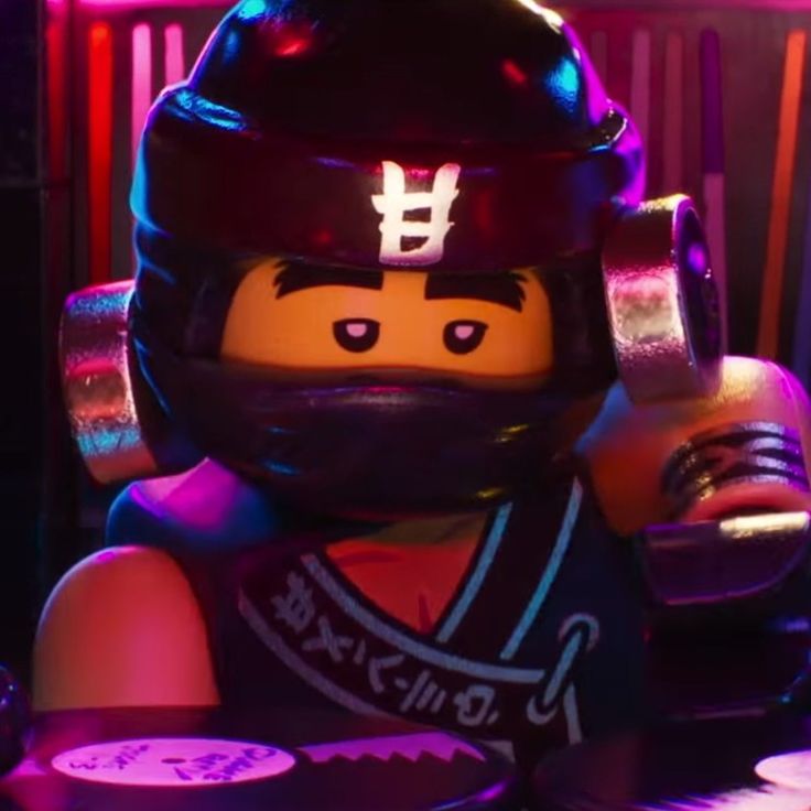 a lego man wearing a helmet sitting at a table