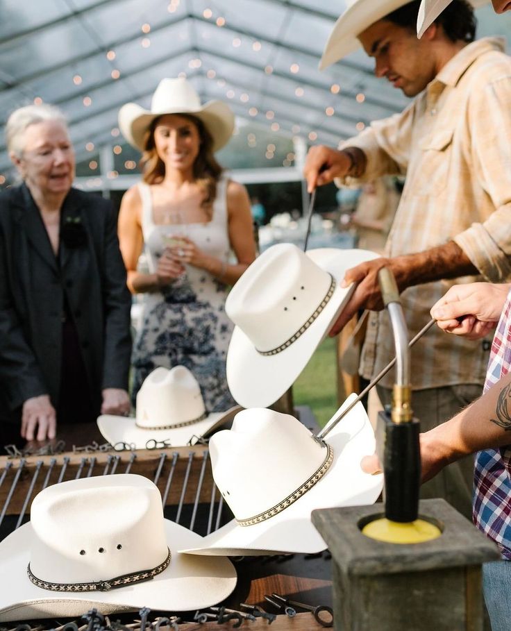 a group of people standing around a table with hats on it