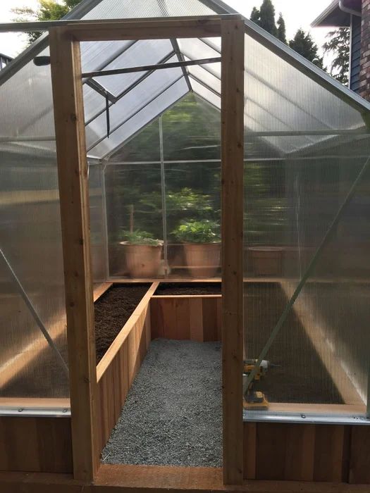 the inside of a small greenhouse with plants in it