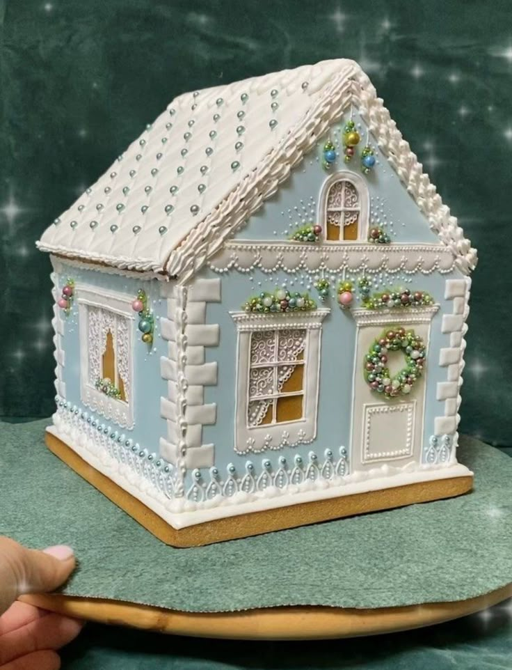 a blue and white gingerbread house on a plate