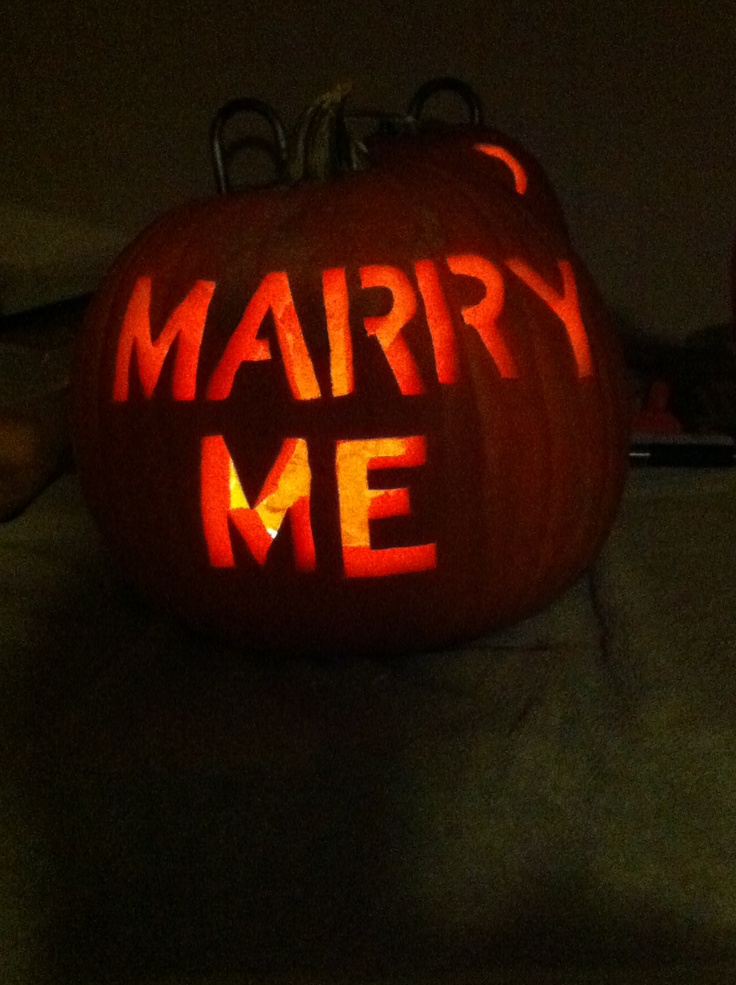 a carved pumpkin with the words marry me written on it's face in red