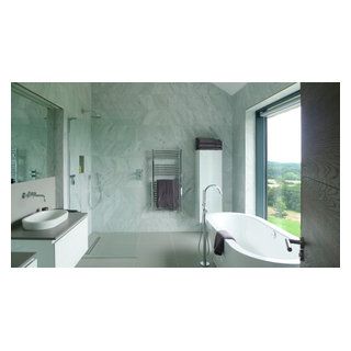 a bathroom with a tub, sink and large window looking out on the countryside outside