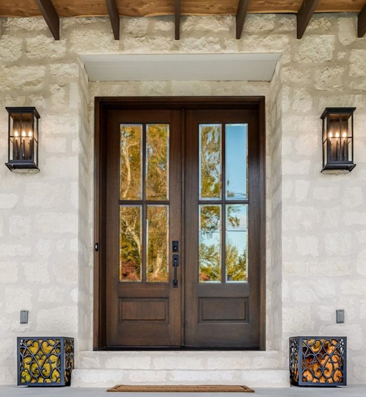 the front door to a home with two lights on each side