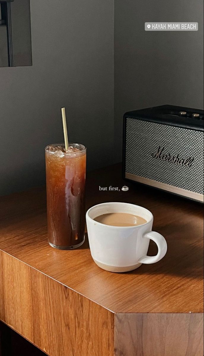 a cup of coffee next to a radio on a table