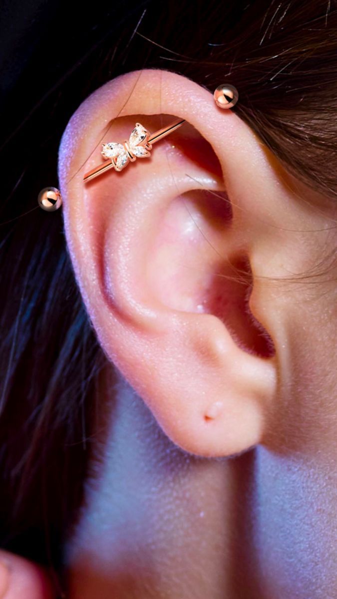 a close up of a person's ear with two piercings