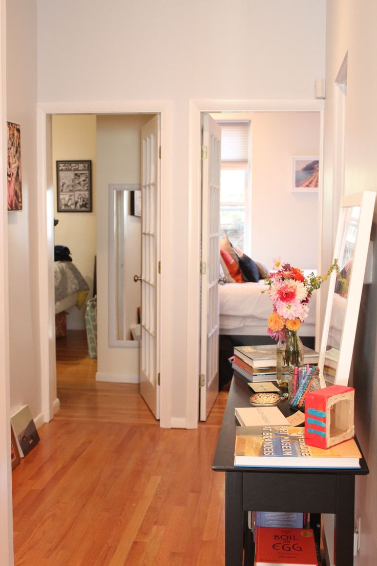 a living room with hard wood floors and white walls in the background is a bed