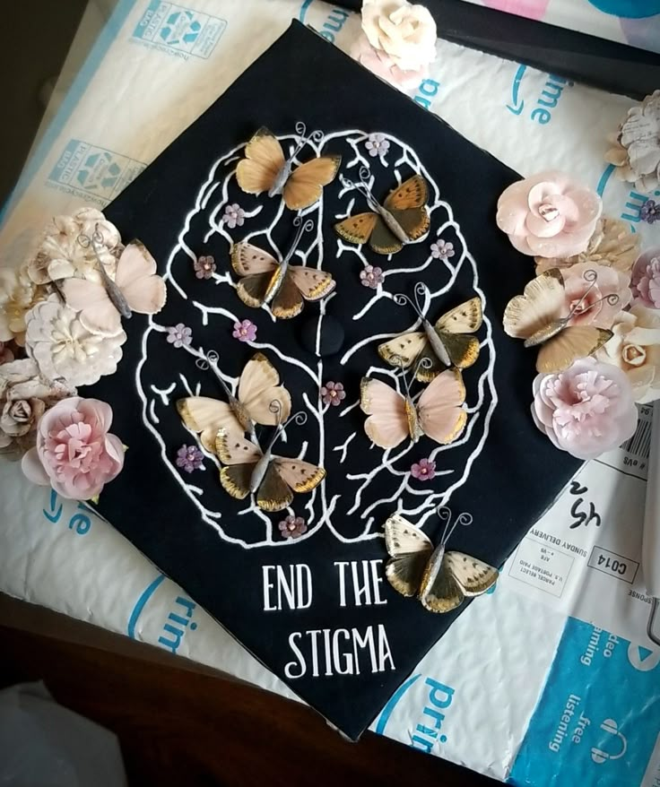 a black graduation cap with flowers and butterflies on it that says, end the stigma