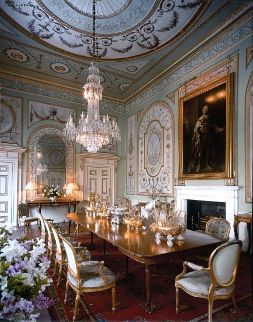 an ornate dining room with chandelier and chairs